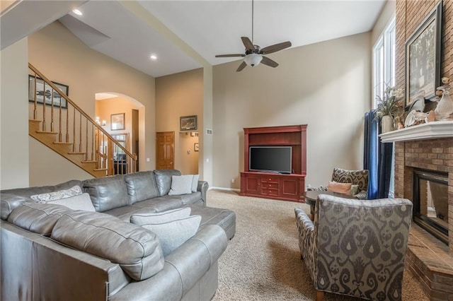 4902 Corinth Dr, Saint Joseph, MO 64506 - living area featuring carpet flooring, arched walkways, stairs, ceiling fan, and a fireplace