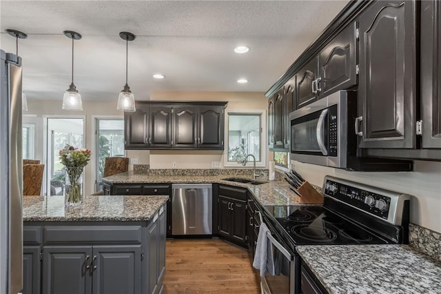 4902 Corinth Dr, Saint Joseph, MO 64506 - kitchen with stainless steel appliances, wood finished floors, decorative light fixtures, stone countertops, and recessed lighting