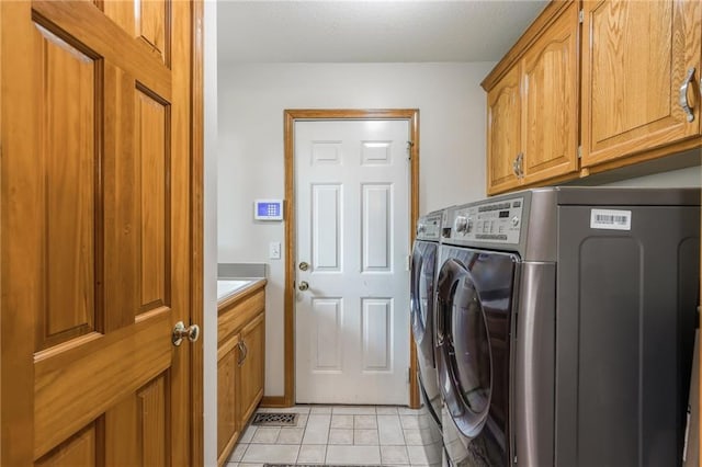 4902 Corinth Dr, Saint Joseph, MO 64506 - laundry area featuring cabinet space, separate washer and dryer, and light tile patterned flooring