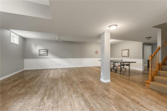 4902 Corinth Dr, Saint Joseph, MO 64506 - basement with wood finished floors, stairs, a wainscoted wall, a ceiling fan, and a textured ceiling