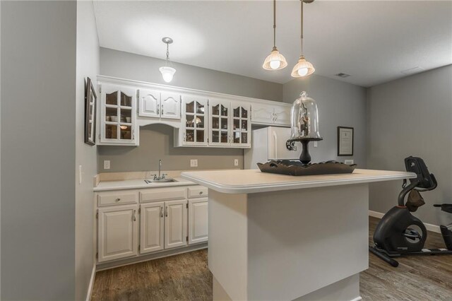 4902 Corinth Dr, Saint Joseph, MO 64506 - kitchen with dark wood-style floors, white fridge, glass insert cabinets, light countertops, and a center island