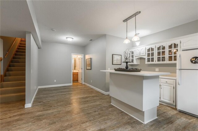 4902 Corinth Dr, Saint Joseph, MO 64506 - kitchen featuring freestanding refrigerator, white cabinets, dark wood-type flooring, glass insert cabinets, and a textured ceiling