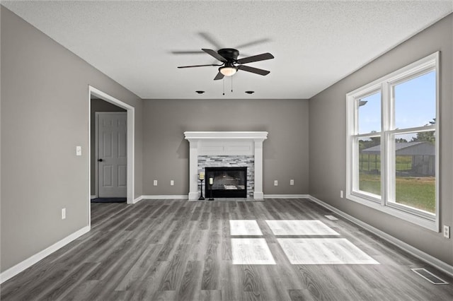 23404 Waverly Rd, Spring Hill, KS 66083 - unfurnished living room with ceiling fan, wood finished floors, a glass covered fireplace, and a textured ceiling