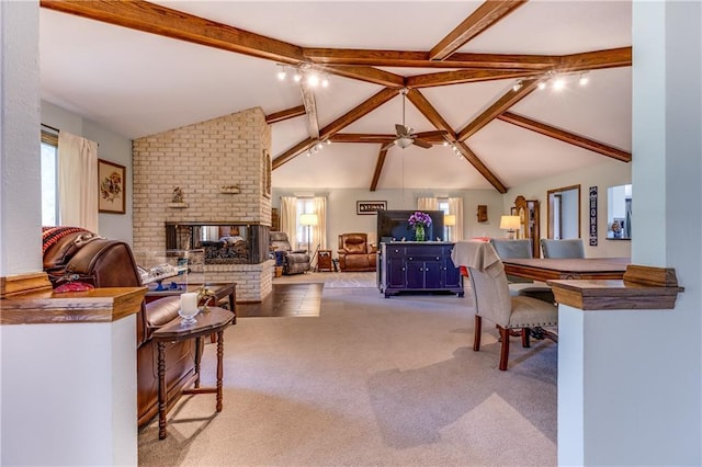 601 W 14th St, Pleasanton, KS 66075 - carpeted living area featuring beam ceiling, a fireplace, a ceiling fan, and high vaulted ceiling