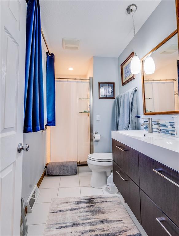 601 W 14th St, Pleasanton, KS 66075 - bathroom featuring tile patterned floors, vanity, and a shower stall