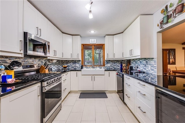 601 W 14th St, Pleasanton, KS 66075 - kitchen with stainless steel appliances, wine cooler, a textured ceiling, and backsplash