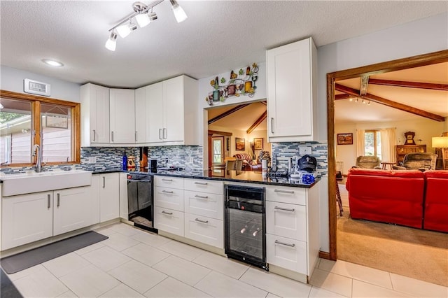 601 W 14th St, Pleasanton, KS 66075 - kitchen featuring beverage cooler, dishwasher, a textured ceiling, tasteful backsplash, and white cabinets