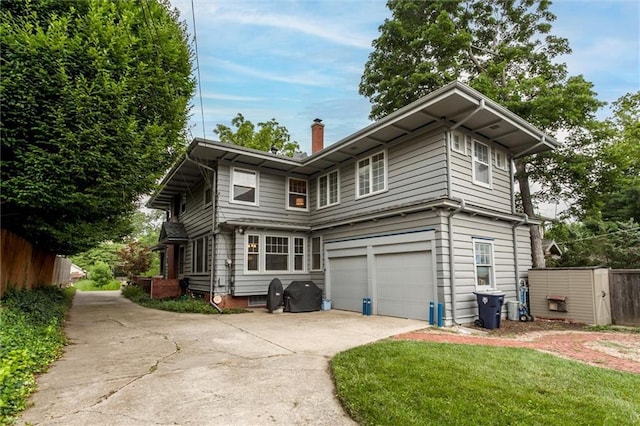6033 Central St, Kansas City, MO 64113 - view of front of home featuring driveway, a garage, and a chimney