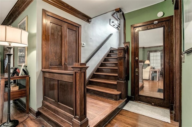 6033 Central St, Kansas City, MO 64113 - staircase featuring wood finished floors and ornamental molding