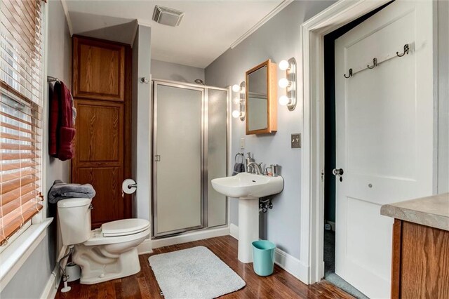 6033 Central St, Kansas City, MO 64113 - full bath featuring a shower stall, wood finished floors, and plenty of natural light