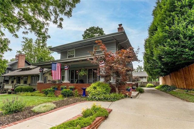 6033 Central St, Kansas City, MO 64113 - view of front facade with a porch and a chimney
