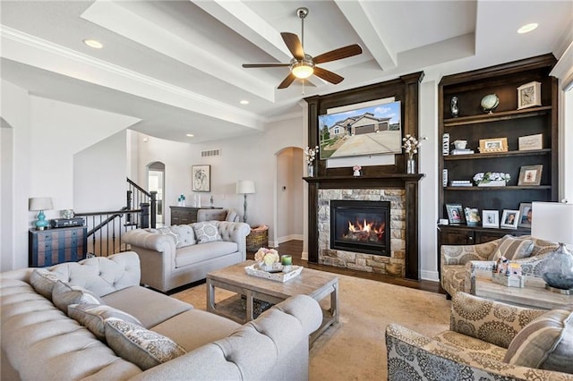 1401 Spurlock Cv, Raymore, MO 64083 - living room with arched walkways, a stone fireplace, recessed lighting, a ceiling fan, and beam ceiling