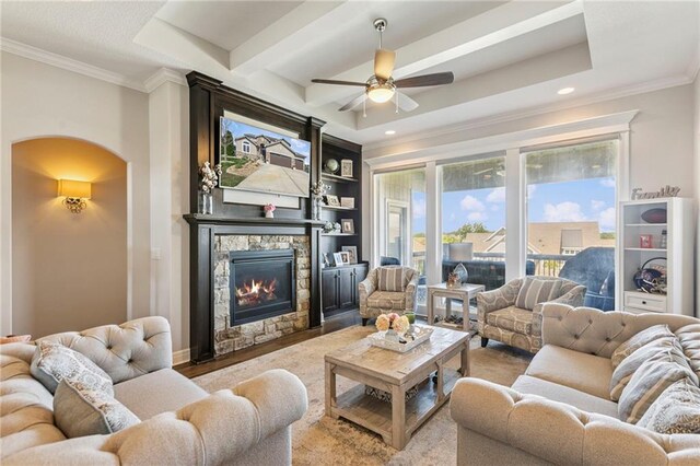 1401 Spurlock Cv, Raymore, MO 64083 - living area with arched walkways, a ceiling fan, a fireplace, ornamental molding, and recessed lighting