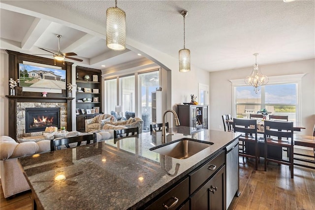 1401 Spurlock Cv, Raymore, MO 64083 - kitchen with decorative light fixtures, dark wood-style flooring, open floor plan, a textured ceiling, and beam ceiling