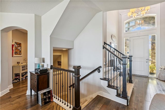 1401 Spurlock Cv, Raymore, MO 64083 - entryway featuring wood-type flooring, healthy amount of natural light, arched walkways, and high vaulted ceiling