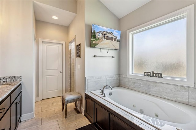 1401 Spurlock Cv, Raymore, MO 64083 - full bath with vanity, a whirlpool tub, and vaulted ceiling