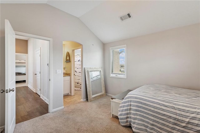 1401 Spurlock Cv, Raymore, MO 64083 - carpeted bedroom with vaulted ceiling, arched walkways, and connected bathroom