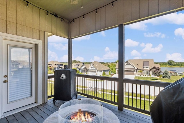 1401 Spurlock Cv, Raymore, MO 64083 - deck with a residential view, a ceiling fan, a fire pit, and a water view