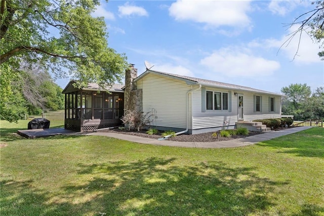 20212 S Carriage Ln, Peculiar, MO 64078 - view of front of house with a sunroom, a chimney, and a front yard