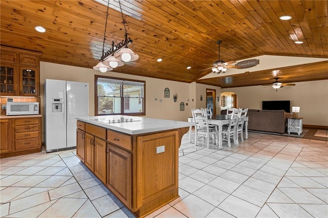 20212 S Carriage Ln, Peculiar, MO 64078 - kitchen with white appliances, lofted ceiling, brown cabinetry, light tile patterned flooring, and a ceiling fan