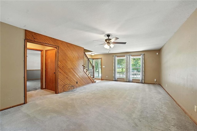 802 S Morgan Dr, Peculiar, MO 64078 - unfurnished room with stairway, carpet flooring, a ceiling fan, and wood walls