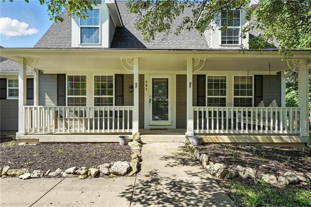 802 S Morgan Dr, Peculiar, MO 64078 - property entrance with a porch and roof with shingles