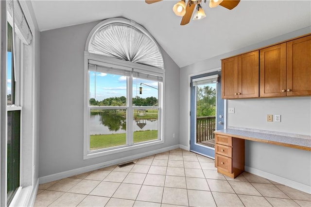13785 E Nelson Rd, Nevada, MO 64772 - kitchen with vaulted ceiling, built in desk, ceiling fan, light countertops, and brown cabinets
