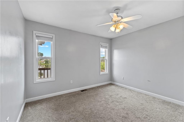 13785 E Nelson Rd, Nevada, MO 64772 - carpeted empty room with plenty of natural light and ceiling fan
