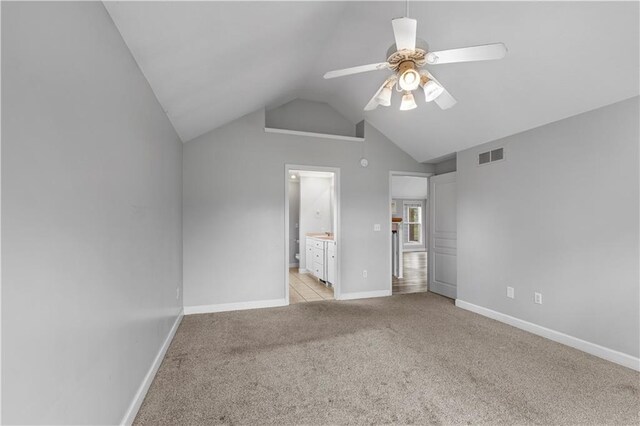 13785 E Nelson Rd, Nevada, MO 64772 - unfurnished bedroom featuring light carpet, vaulted ceiling, ensuite bath, and a ceiling fan