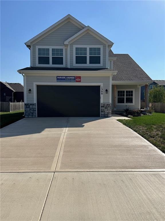 1309 N 4th St E, Louisburg, KS 66053 - craftsman inspired home featuring an attached garage, concrete driveway, and stone siding