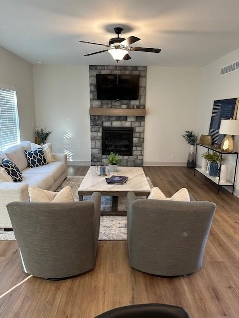 1309 N 4th St E, Louisburg, KS 66053 - living area with a stone fireplace, ceiling fan, and wood finished floors