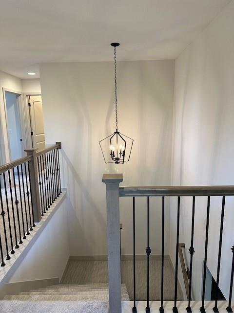 1309 N 4th St E, Louisburg, KS 66053 - stairs featuring baseboards and a chandelier