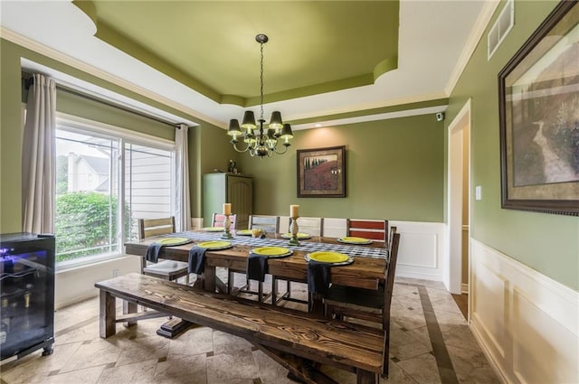 2621 SE 5th St, Lees Summit, MO 64063 - dining space with a chandelier, a tray ceiling, crown molding, a wainscoted wall, and a decorative wall