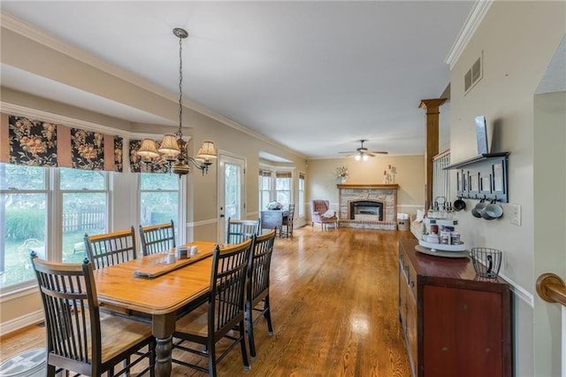 2621 SE 5th St, Lees Summit, MO 64063 - dining space with a fireplace with raised hearth, plenty of natural light, wood finished floors, a ceiling fan, and ornamental molding
