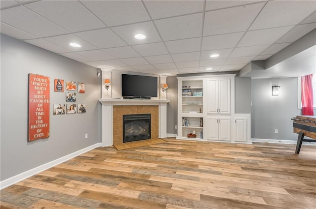 2621 SE 5th St, Lees Summit, MO 64063 - unfurnished living room with light wood-style floors, a tile fireplace, recessed lighting, and built in shelves