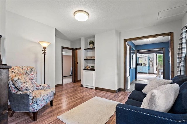 314 E Nichols St, Spring Hill, KS 66083 - living area featuring wood finished floors, built in shelves, and a textured ceiling