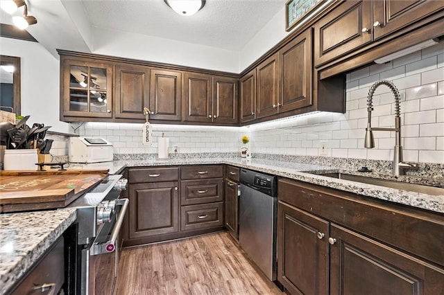 314 E Nichols St, Spring Hill, KS 66083 - kitchen featuring appliances with stainless steel finishes, light wood-style flooring, dark brown cabinets, backsplash, and light stone countertops