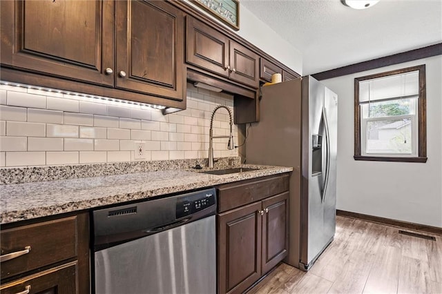 314 E Nichols St, Spring Hill, KS 66083 - kitchen with appliances with stainless steel finishes, tasteful backsplash, dark brown cabinets, light wood-style flooring, and a textured ceiling