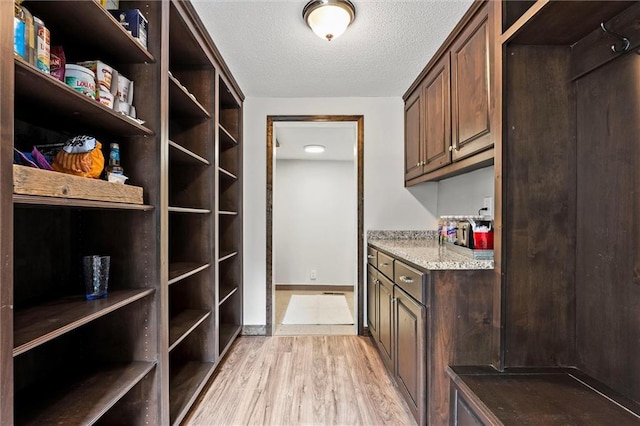 314 E Nichols St, Spring Hill, KS 66083 - laundry room featuring light wood finished floors and a textured ceiling