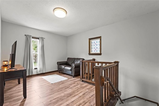 314 E Nichols St, Spring Hill, KS 66083 - sitting room with an upstairs landing, light wood finished floors, and a textured ceiling