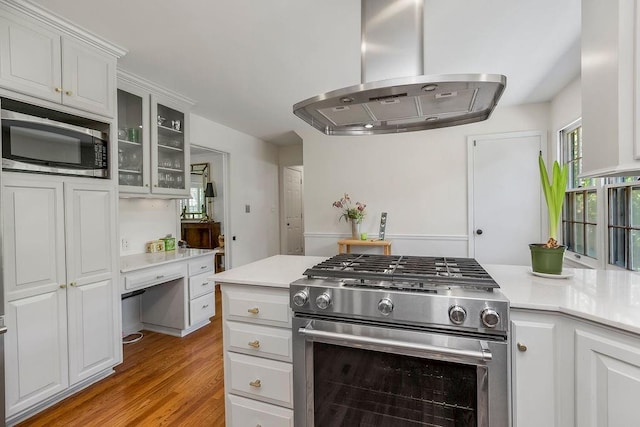 9201 Ensley Ln, Leawood, KS 66206 - kitchen with appliances with stainless steel finishes, extractor fan, light countertops, light wood-style flooring, and glass insert cabinets