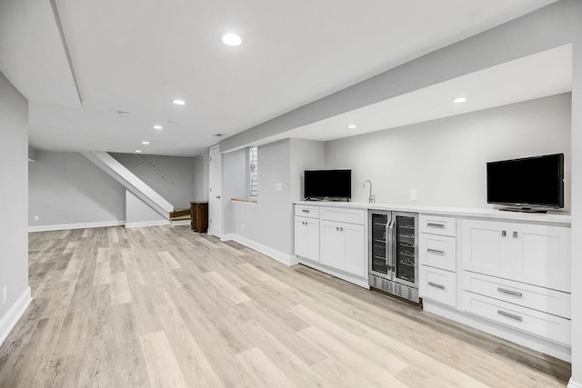 9201 Ensley Ln, Leawood, KS 66206 - unfurnished living room featuring beverage cooler, wet bar, light wood-style flooring, recessed lighting, and stairway