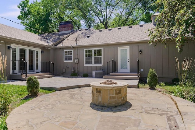 9201 Ensley Ln, Leawood, KS 66206 - back of property featuring a chimney, board and batten siding, a patio area, and an outdoor fire pit