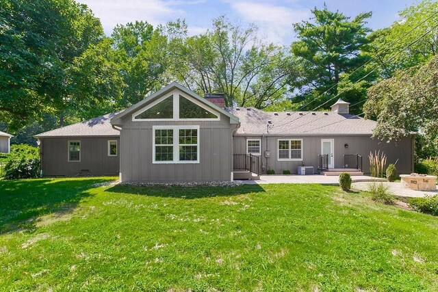 9201 Ensley Ln, Leawood, KS 66206 - back of property with a chimney, a yard, a patio, and board and batten siding