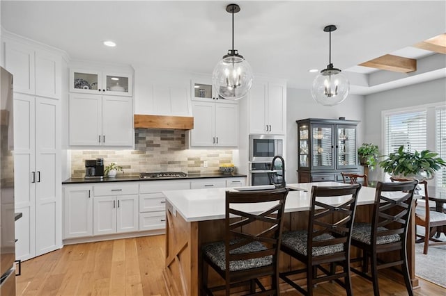 9260 Saddletop St, Lenexa, KS 66227 - kitchen featuring light wood-type flooring, appliances with stainless steel finishes, tasteful backsplash, an island with sink, and recessed lighting