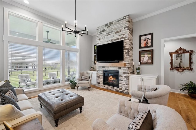 9260 Saddletop St, Lenexa, KS 66227 - living room featuring crown molding, wood finished floors, healthy amount of natural light, a chandelier, and a fireplace