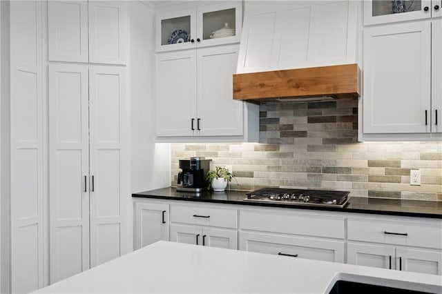9260 Saddletop St, Lenexa, KS 66227 - kitchen with stainless steel gas cooktop, decorative backsplash, white cabinets, and glass insert cabinets