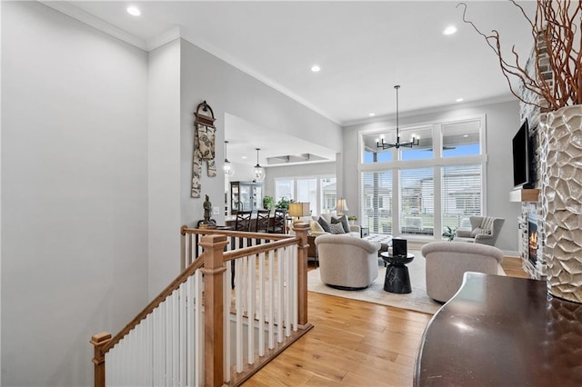 9260 Saddletop St, Lenexa, KS 66227 - living area featuring a fireplace, recessed lighting, a chandelier, crown molding, and light wood finished floors