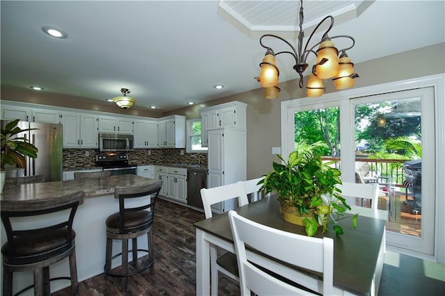 1005 Hunters Rd, Blue Springs, MO 64014 - kitchen featuring stainless steel microwave, refrigerator, electric stove, dishwashing machine, and a chandelier
