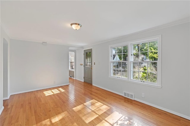 7712 Mcgee St, Kansas City, MO 64114 - empty room featuring arched walkways, ornamental molding, and light wood finished floors